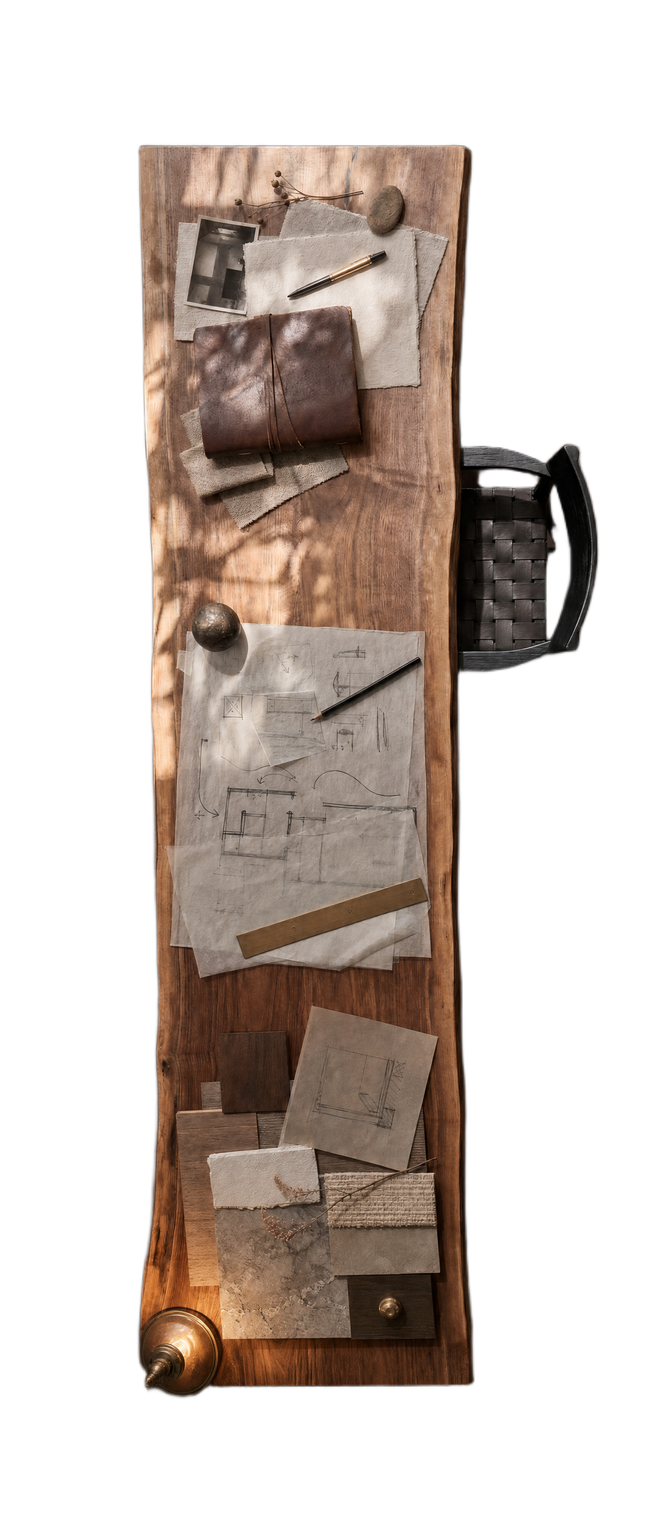 A working table seen from above — sketches, leather notebook, materials, lamp and crumpled paper
