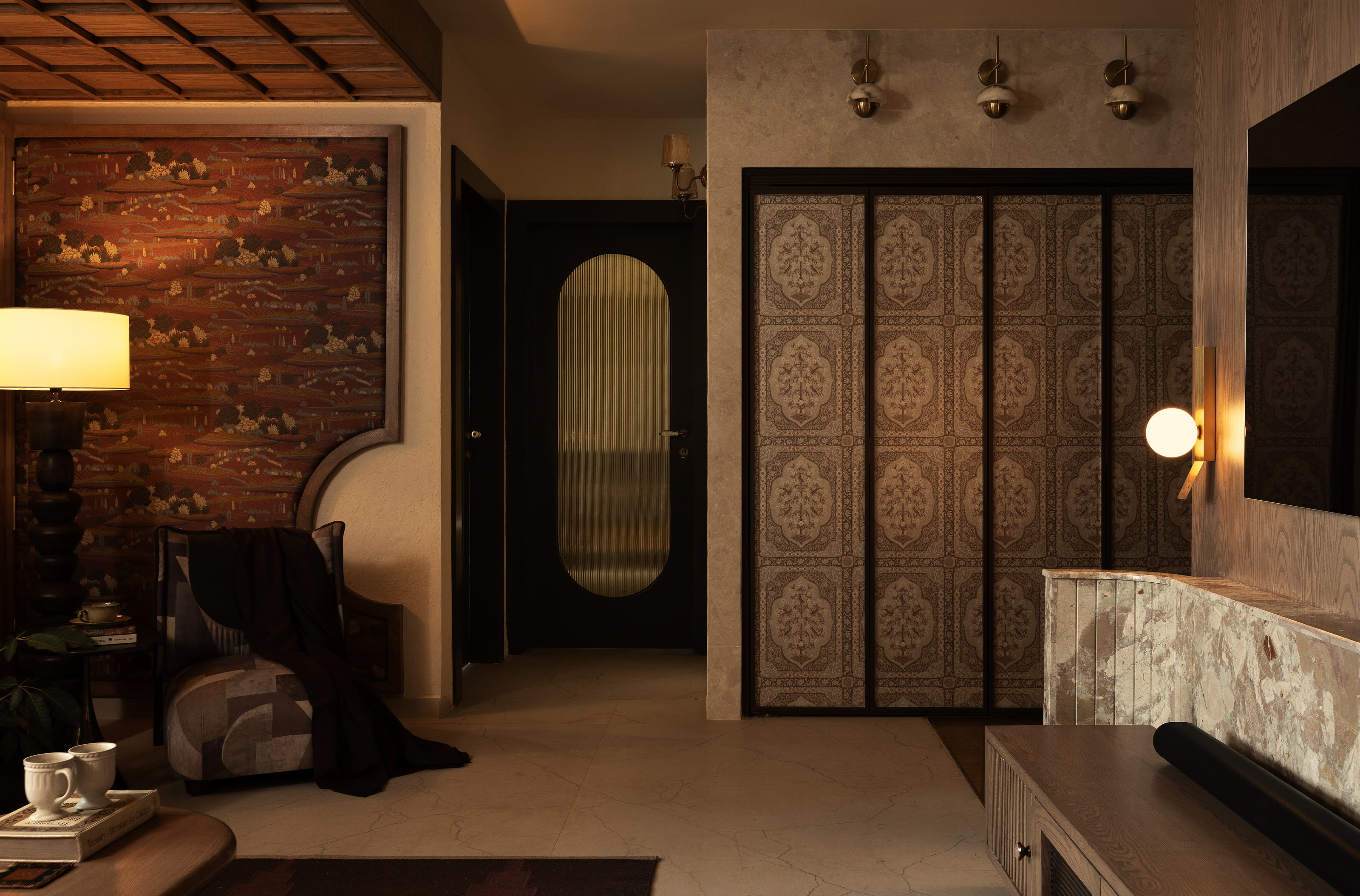 Warm-lit entry with patterned wall, lamp, doorway, ceiling grid and carved panels