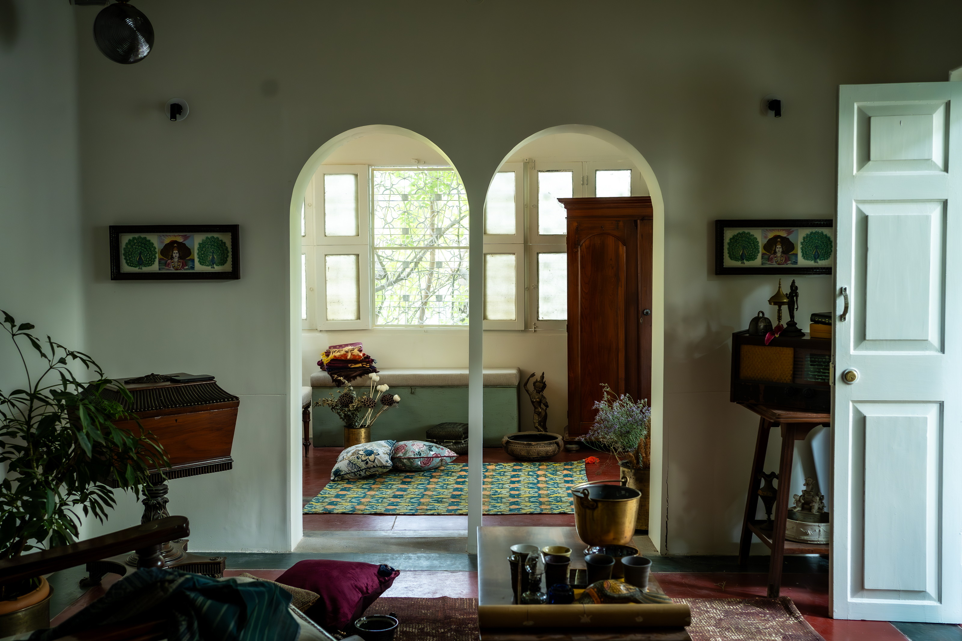 Entry with chinoiserie artwork, arched door detail, carved panels and warm lamp glow